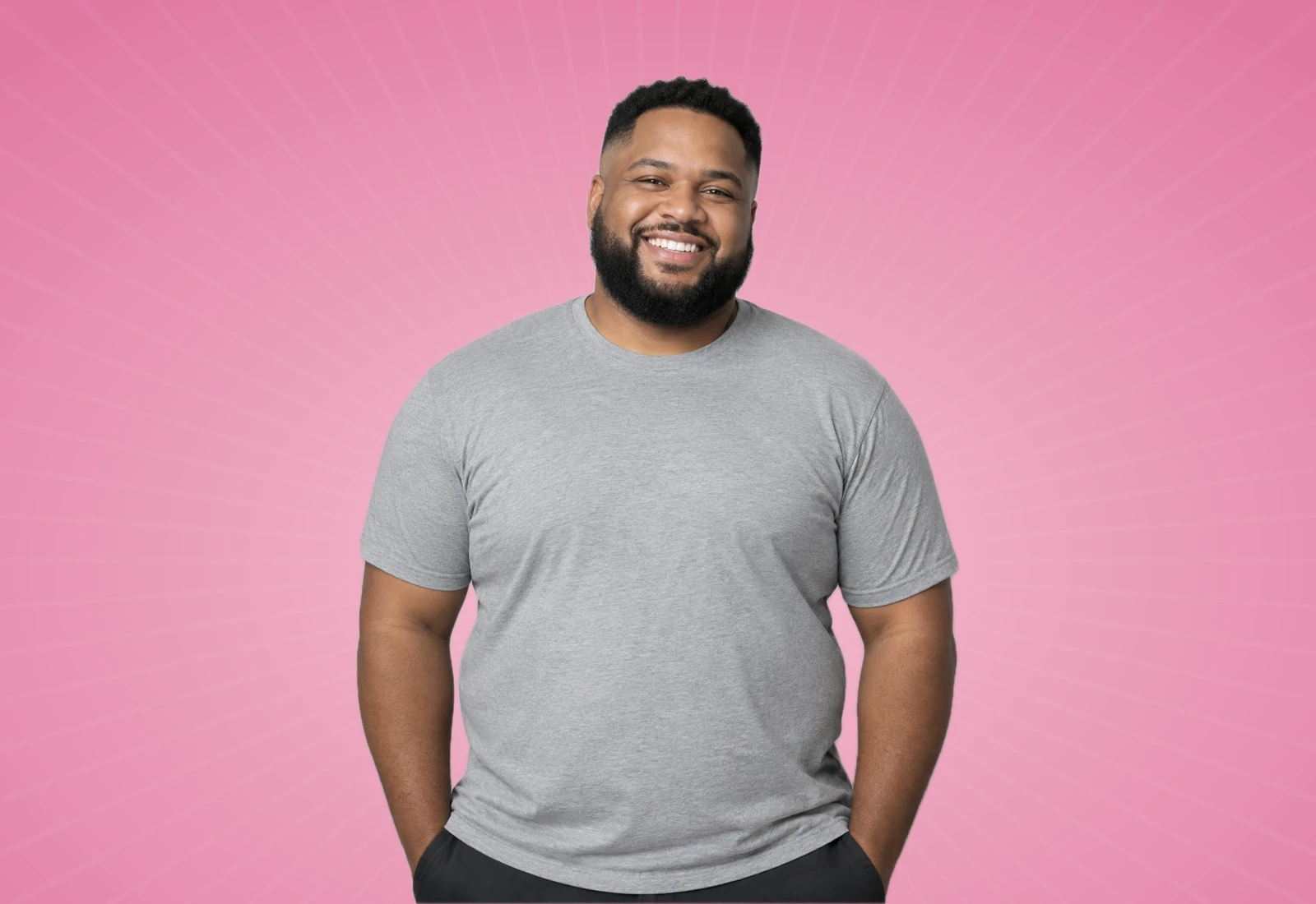 Smiling man in a grey t-shirt on a rose background